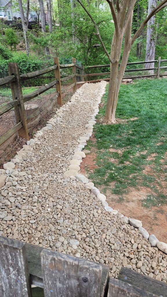 A beautiful dry creek bed lining the yard parameter.